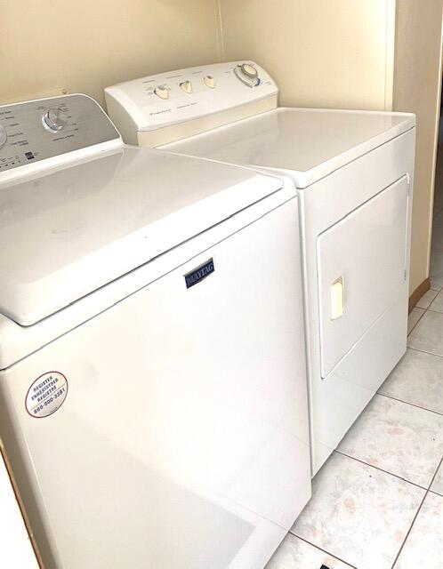 washroom with light tile patterned floors and washer and dryer