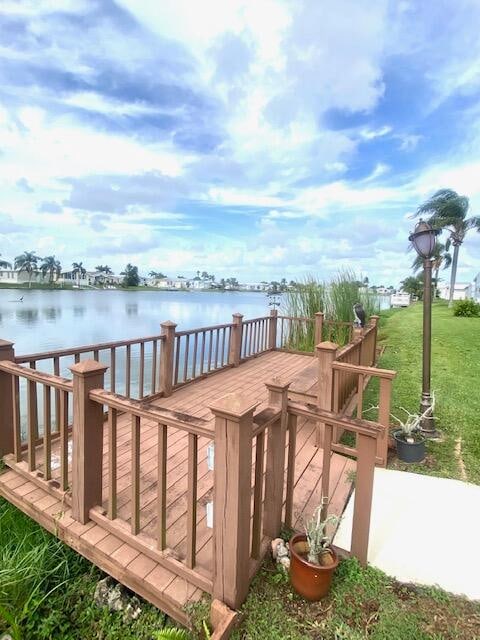 dock area with a deck with water view and a yard