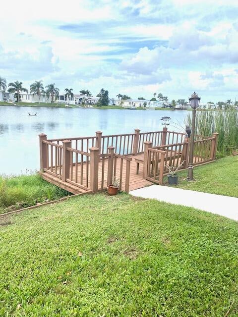 dock area with a lawn and a water view