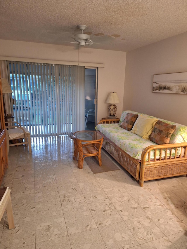 living room featuring a textured ceiling and ceiling fan