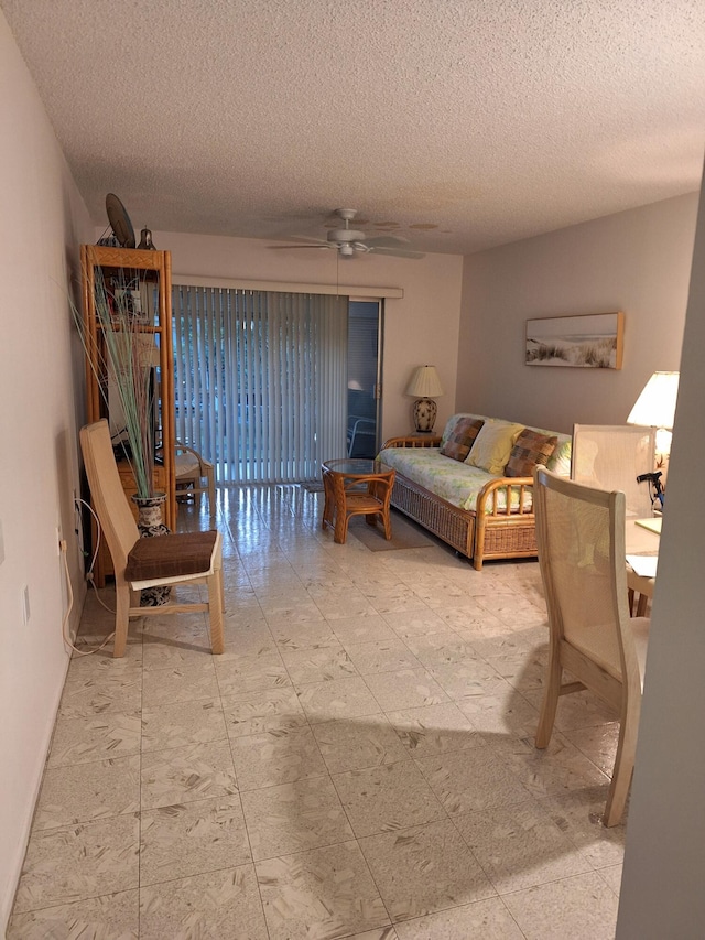 living room with ceiling fan and a textured ceiling