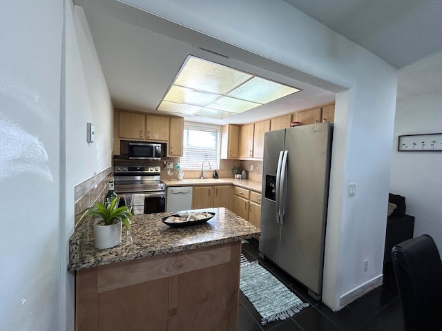 kitchen featuring backsplash, stainless steel appliances, dark tile patterned floors, sink, and light brown cabinets