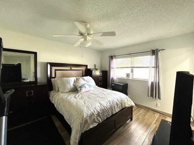 bedroom featuring ceiling fan, a textured ceiling, and light hardwood / wood-style flooring