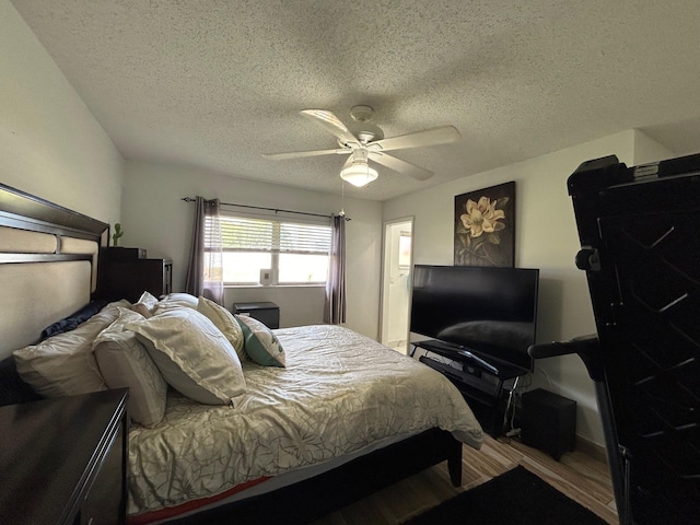 bedroom featuring hardwood / wood-style floors, a textured ceiling, and ceiling fan