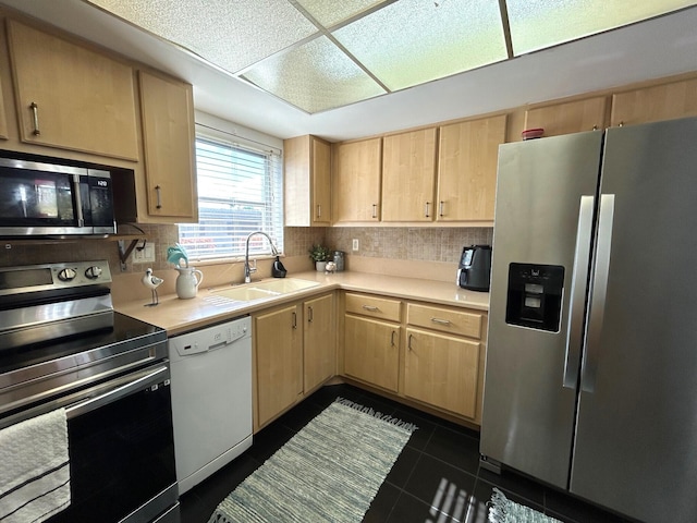 kitchen with tasteful backsplash, sink, stainless steel appliances, and light brown cabinets