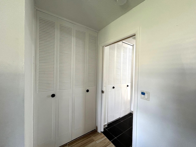 hall featuring a textured ceiling and dark hardwood / wood-style floors