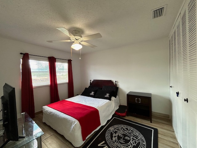 bedroom featuring a textured ceiling, light hardwood / wood-style flooring, and ceiling fan