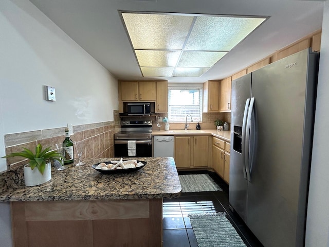 kitchen with light stone countertops, light brown cabinets, tasteful backsplash, black appliances, and dark tile patterned flooring