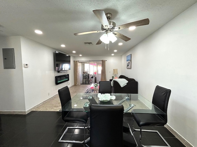 dining space with electric panel, ceiling fan, tile patterned flooring, and a textured ceiling