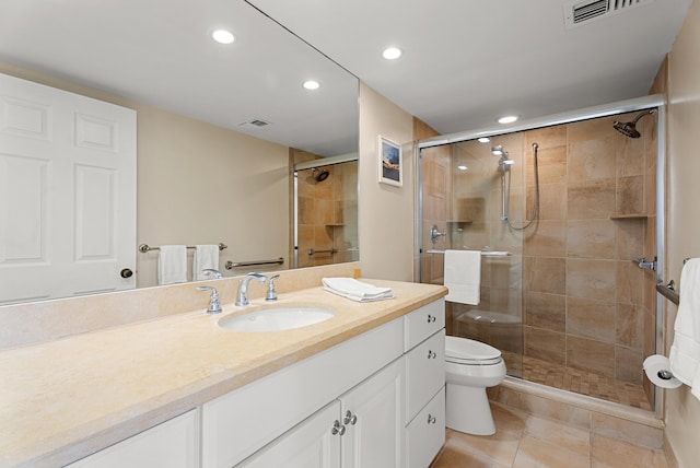 bathroom featuring tile patterned flooring, vanity, toilet, and a shower with door