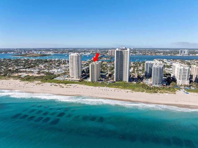 birds eye view of property with a water view and a beach view