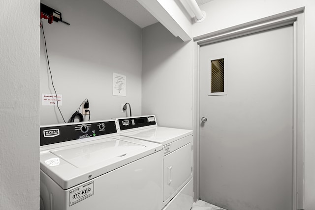 clothes washing area with washer and clothes dryer