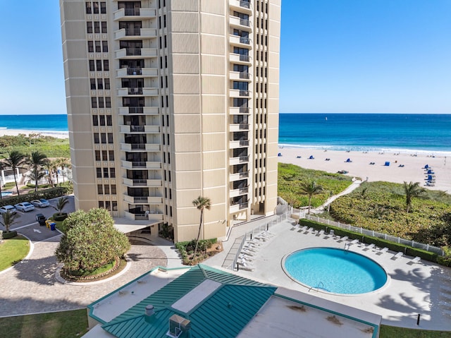 view of pool featuring a view of the beach and a water view