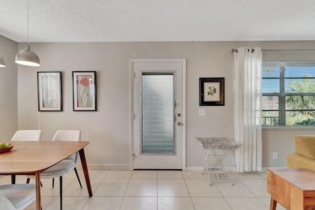 dining space with light tile patterned flooring and a textured ceiling