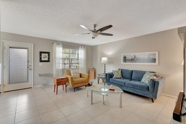 living room featuring light tile patterned flooring, a textured ceiling, and ceiling fan