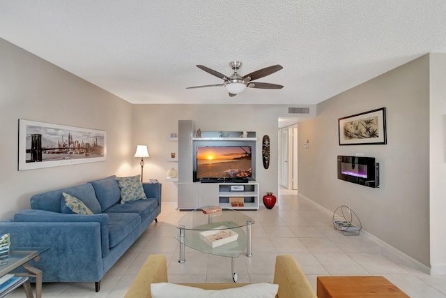 living room featuring light tile patterned flooring, a textured ceiling, and ceiling fan