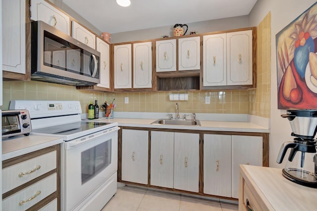 kitchen featuring electric stove, sink, light tile patterned floors, tasteful backsplash, and light brown cabinetry