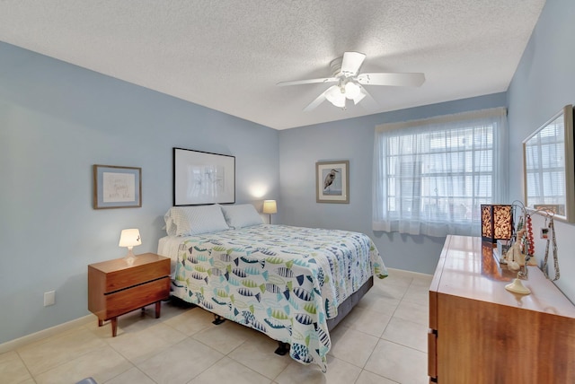 bedroom with ceiling fan, a textured ceiling, and light tile patterned floors