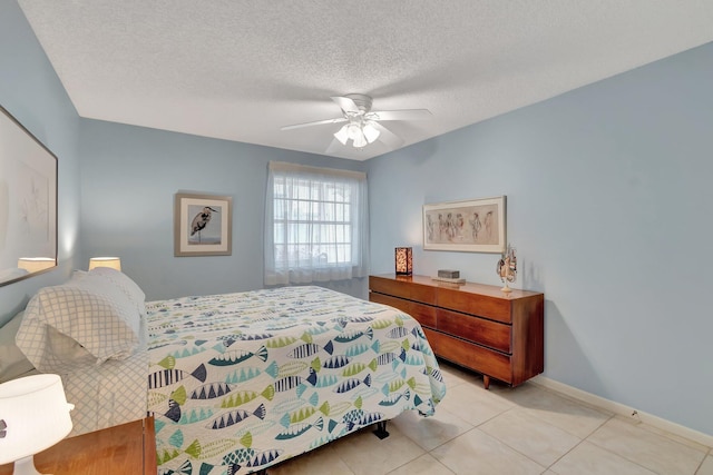 tiled bedroom with a textured ceiling and ceiling fan