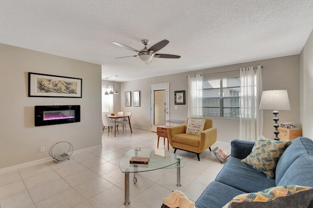 living room with ceiling fan, a textured ceiling, and light tile patterned floors