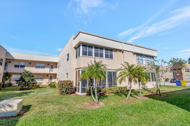 rear view of property featuring a lawn