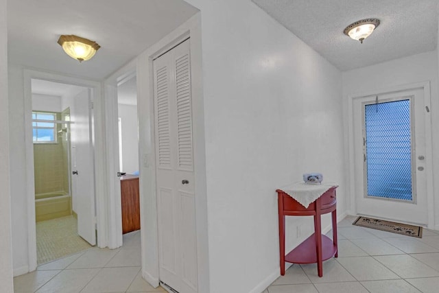 foyer featuring a textured ceiling and light tile patterned flooring