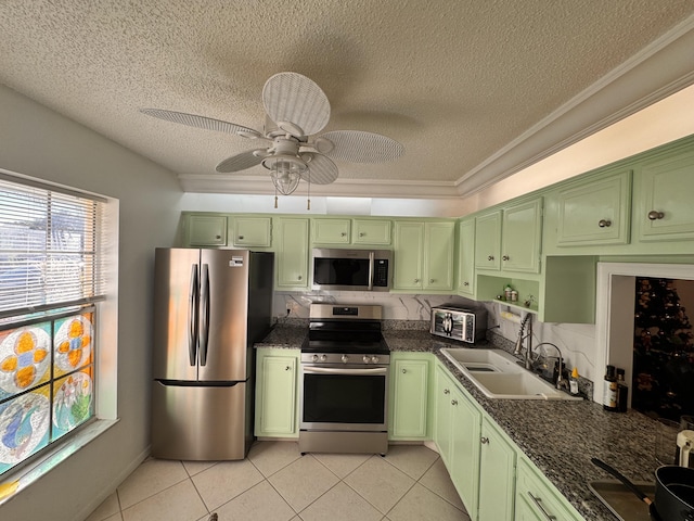 kitchen featuring appliances with stainless steel finishes, a textured ceiling, crown molding, sink, and green cabinetry