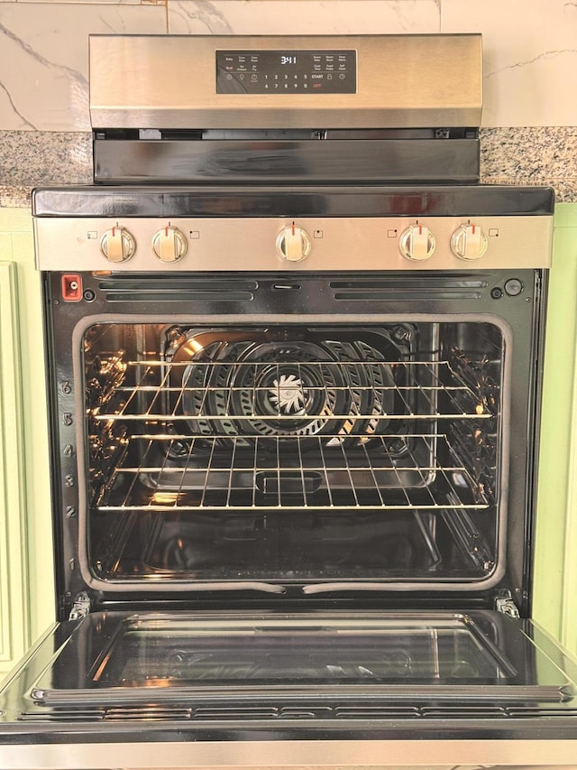 details featuring black electric range and light stone countertops