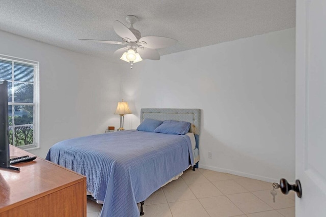 tiled bedroom with ceiling fan and a textured ceiling