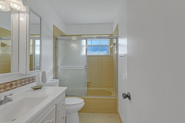 full bathroom featuring tile patterned floors, toilet, a healthy amount of sunlight, and combined bath / shower with glass door