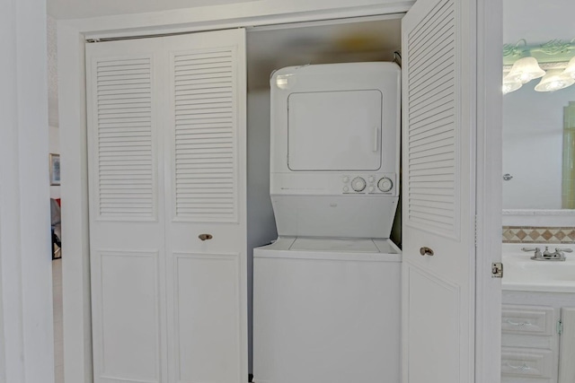 laundry area with stacked washer / dryer and sink