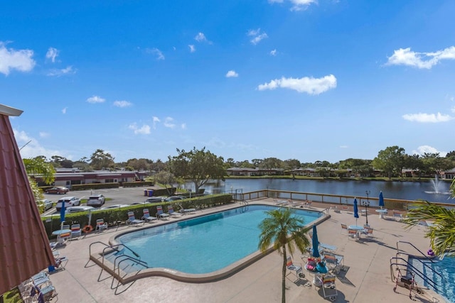 view of pool featuring a water view and a patio area