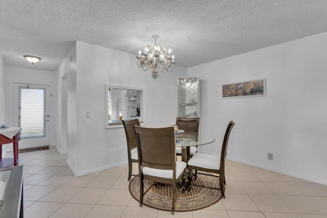 dining area with light tile patterned floors, a textured ceiling, and an inviting chandelier