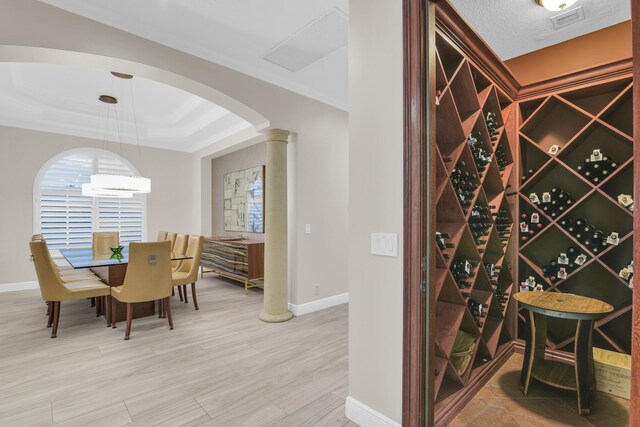 dining space featuring crown molding, a raised ceiling, ceiling fan, and ornate columns