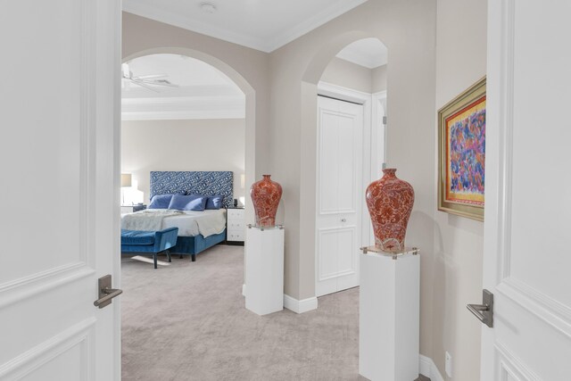 living room featuring a towering ceiling, ornamental molding, a fireplace, and light wood-type flooring