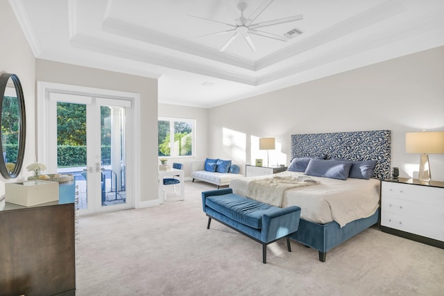 bedroom with light carpet, access to exterior, ceiling fan, and a tray ceiling