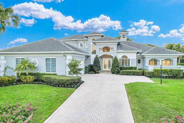 view of front of home with driveway, an attached garage, a tile roof, and a front lawn