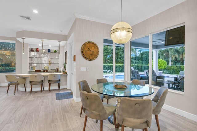 living room with light wood-type flooring, crown molding, visible vents, and a tray ceiling