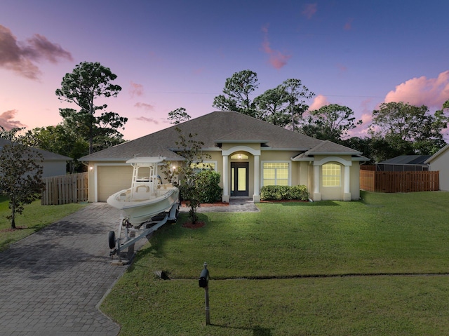 ranch-style home with a yard and a garage