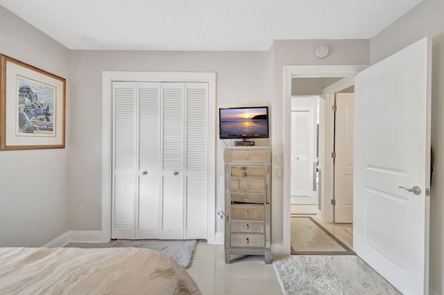 bedroom with a textured ceiling and a closet