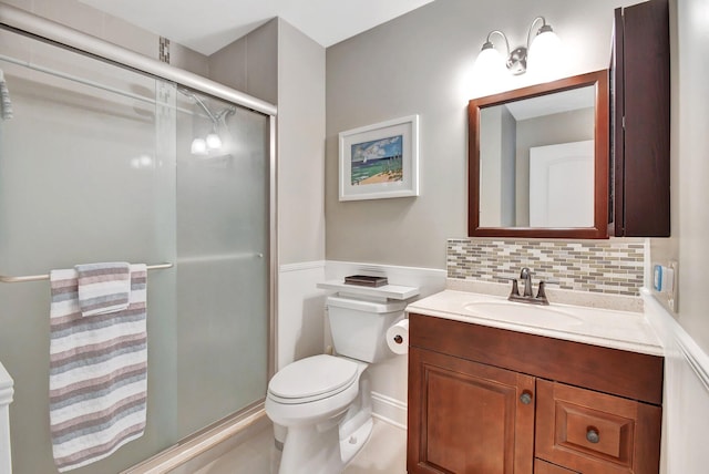 bathroom with vanity, tasteful backsplash, toilet, and walk in shower