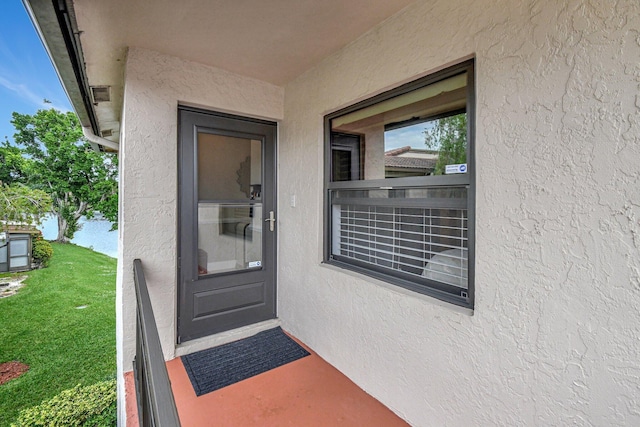 entrance to property featuring a yard and a water view