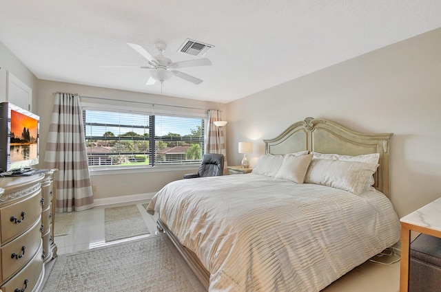 bedroom with ceiling fan and light tile patterned floors