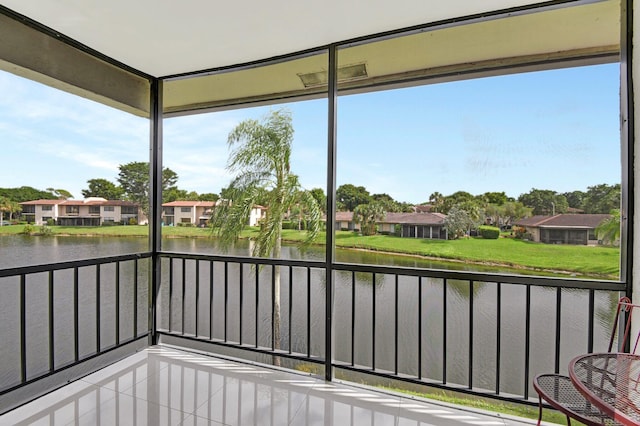 unfurnished sunroom featuring a water view