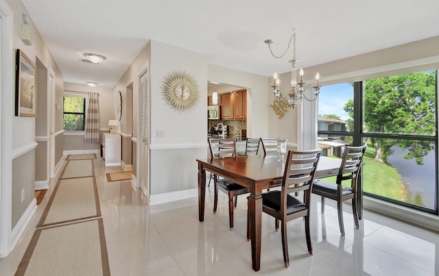 tiled dining area with an inviting chandelier and plenty of natural light