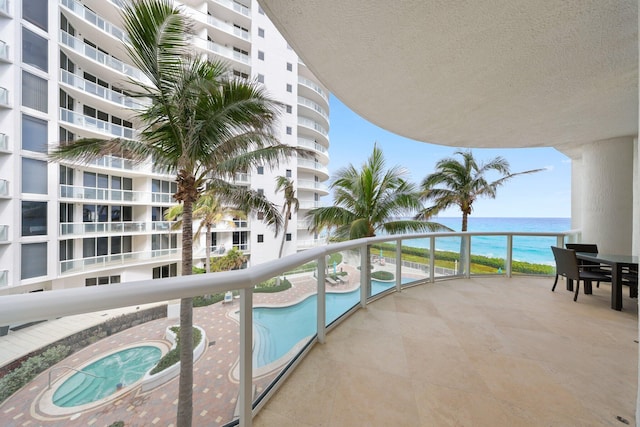 balcony featuring a community hot tub and a water view