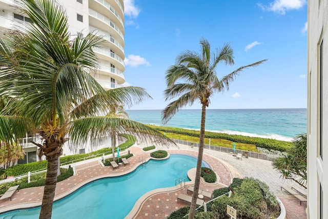 view of swimming pool with a beach view and a water view