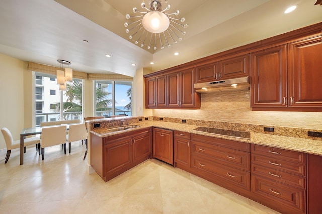 kitchen with decorative backsplash, black electric stovetop, sink, decorative light fixtures, and a notable chandelier