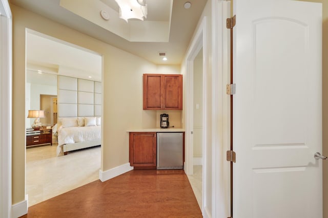 bar featuring stainless steel refrigerator and light hardwood / wood-style floors