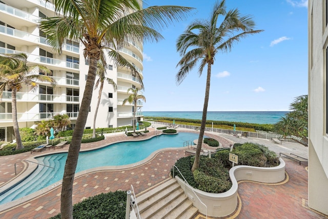 view of swimming pool featuring a patio area and a water view